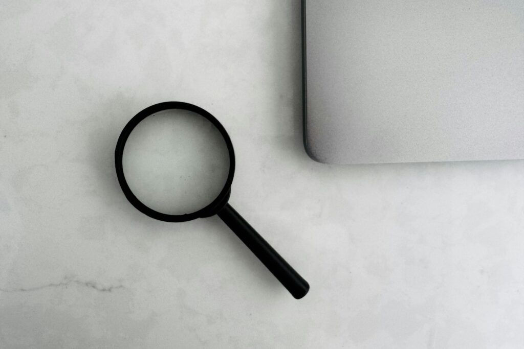 Förstoringsglas bredvid en laptop